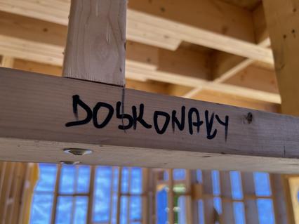 Napis Doskonały na belce konstrukcyjnej w Starym Adamowie